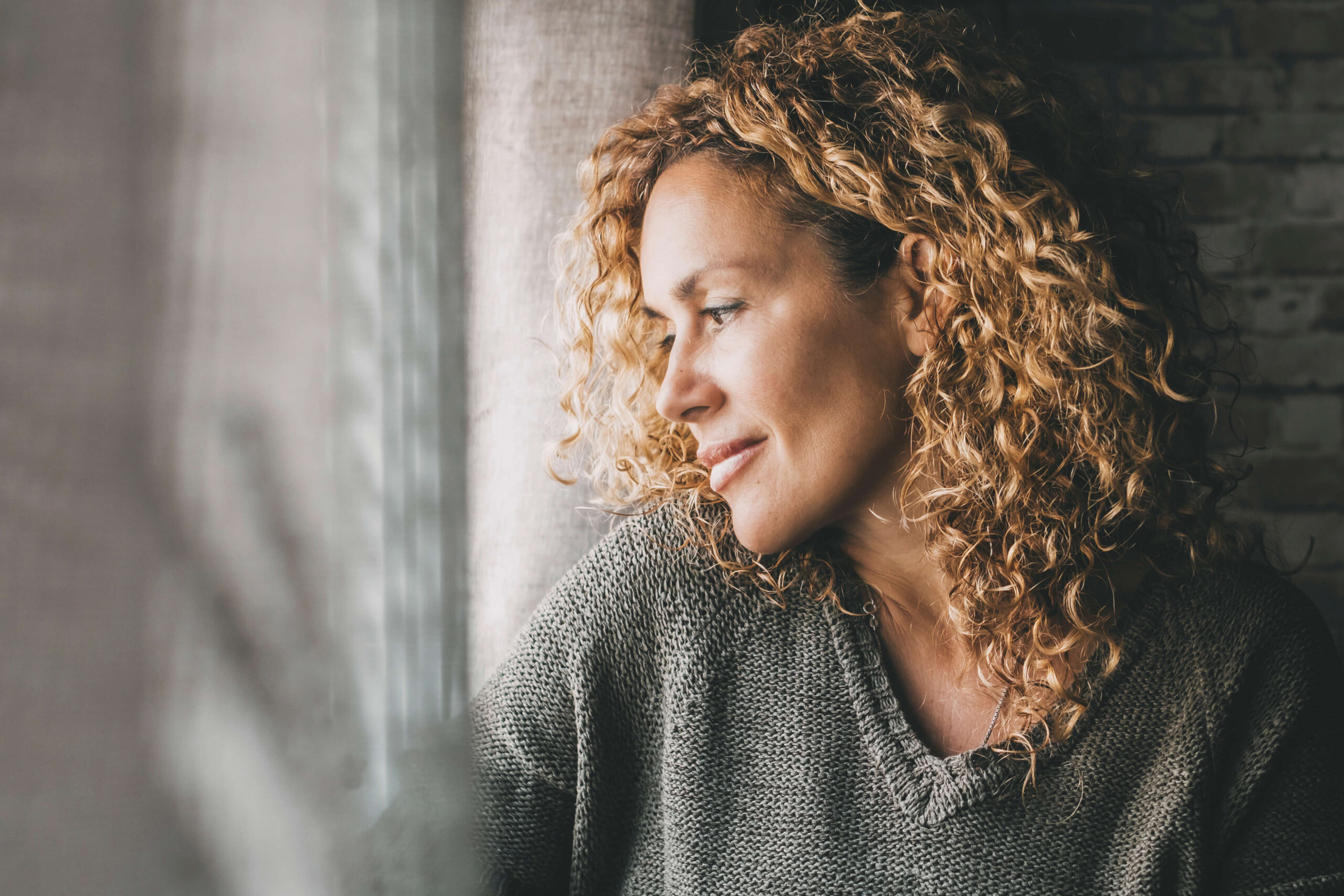 Adult woman looking outside the window